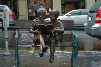 Imagen de una escultura de niños leyendo