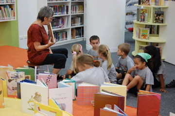 maestra leyendo con niños alrededor